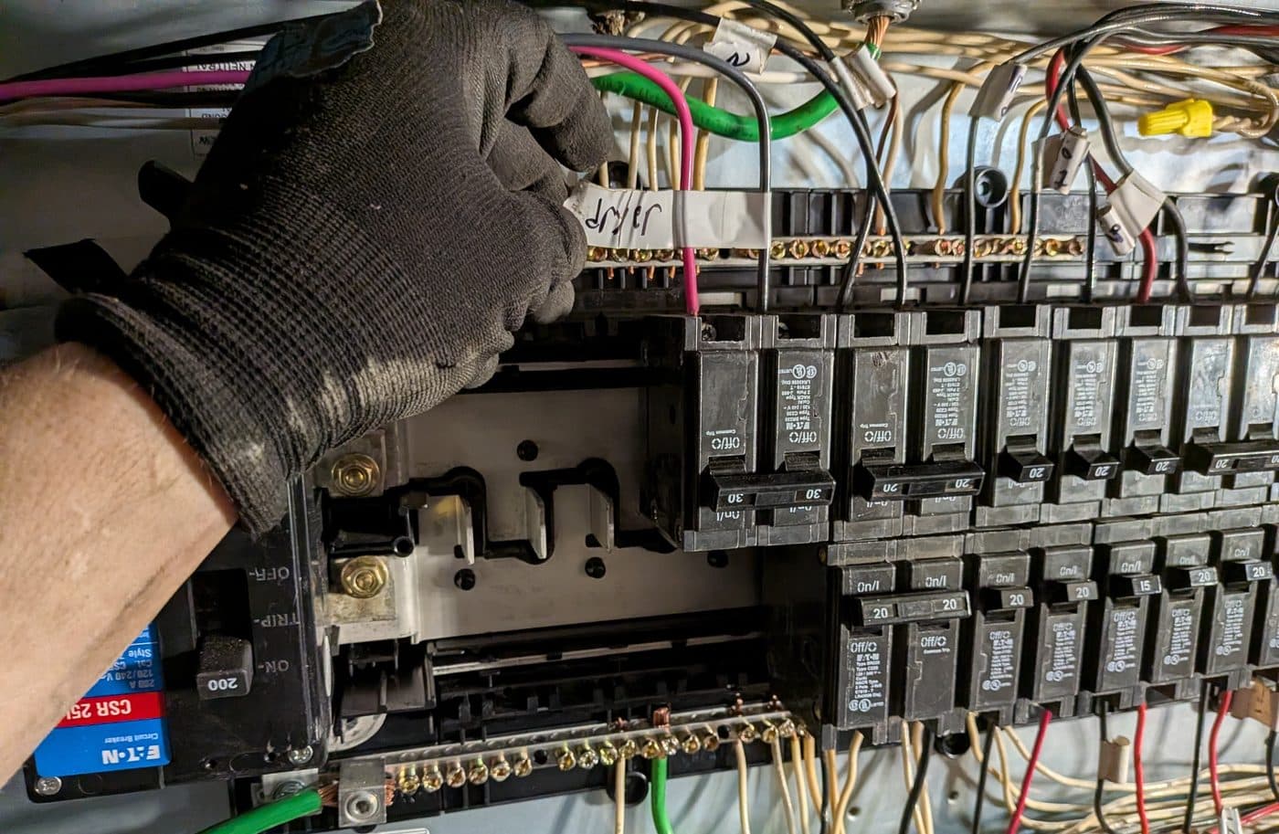 Electrician on a service call working on a panel